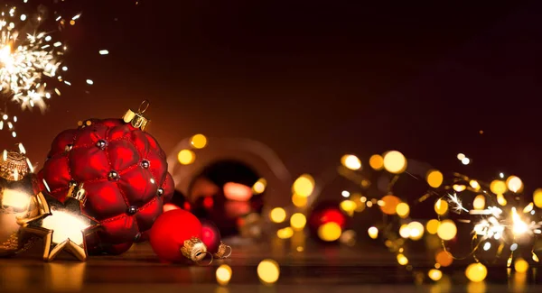 Decorazione natalizia rossa bauble e luci festive sul retro rosso — Foto Stock