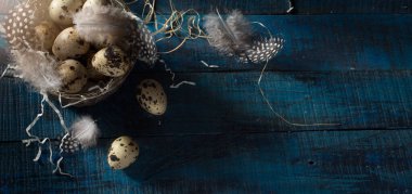 Koyu mavi arka planda gümüş sepetli yumurta ve tüylü Paskalya bayrağı. Üst görünüm, kopyalama alanı olan düz uzanma.