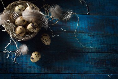 Koyu mavi arka planda gümüş sepetli yumurta ve tüylü Paskalya bayrağı. Üst görünüm, kopyalama alanı olan düz uzanma