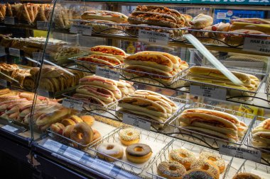 Dükkandaki cam tezgahta turşular, çörekler ve sandviçler