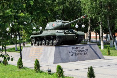 Gusev, Russia - June 19, 2019:  The Soviet tank as the memorial of the World War II in Gusev, Kaliningrad region. Text in Russian: To the memory of the defenders of the fatherland.