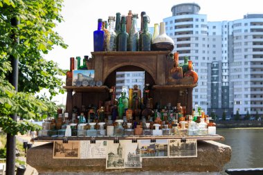 Kaliningrad, Rusya - 20 Haziran 2019: Pregolya Nehri üzerindeki Honey Köprüsü 'nün yakınındaki eski bir ahşap sokak satıcısının rafında mavi, yeşil ve kahverengi tonlarda antika şişe koleksiyonu