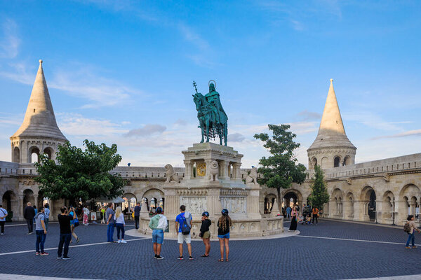 Budapest, Hungary - July 12, 2019: Tourists around the equestrian Statue of Saint Stephen in front of The Matthias Church near the Fisherman's Bastion at the heart of Buda's Castle District.