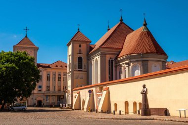 Kaunas, Litvanya - 23 Haziran 2019: Kaunas Papaz Okulu. Kaunas 'taki Kutsal Üçleme Kilisesi papaz okulunun bir parçasıdır. Papaz okulu duvarının yanında Motiejus Valancius 'un bir anıtı görülüyor..
