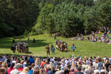 Kernave, Lithuania - July 7, 2018: Reconstruction of the medieval battle during the popular festival Days of Live Archeology in Kernave, ancient capital of Lithuania.  clipart