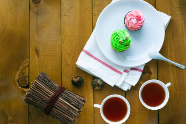 cupcake fincan çay ahşap arka plan üzerinde beyaz bir tabakta
