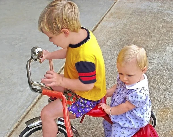 Crianças em um triciclo — Fotografia de Stock