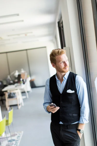 Man with mobile phone in the office — Stock Photo, Image