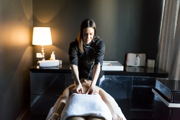 Jovem mulher fazendo uma massagem — Fotografia de Stock