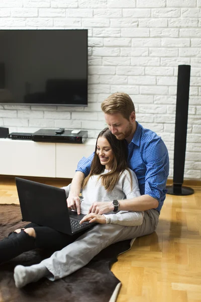 Casal com um laptop em casa — Fotografia de Stock