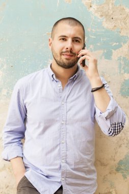 Akıllı telefonu olan genç bir adam.