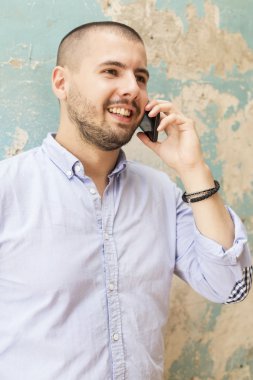 Akıllı telefonu olan genç bir adam.