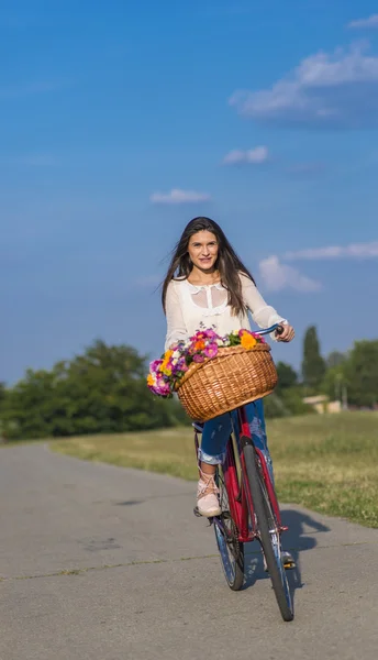 Menina jovem monta uma bicicleta — Fotografia de Stock