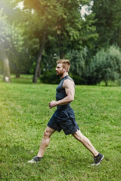 Junger Mann joggt im Park — Stockfoto