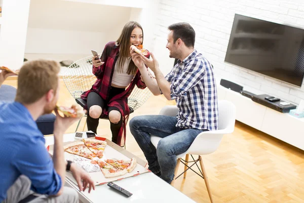 Amigos comendo pizza no quarto — Fotografia de Stock