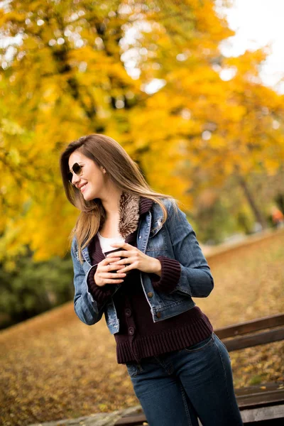 Mujer con café en el parque de otoño — Foto de Stock