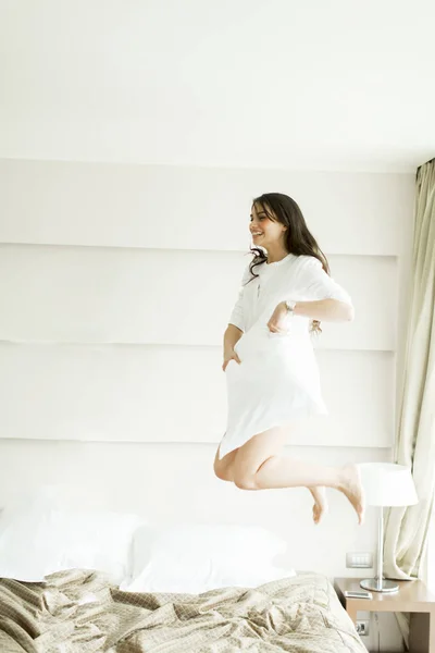 Woman jumping on bed — Stock Photo, Image
