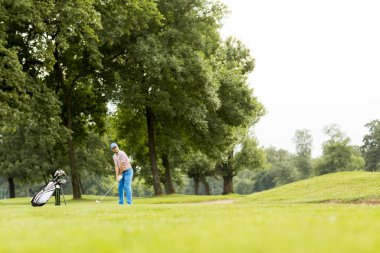 Golf oynayan genç adam.