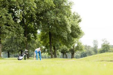 Golf oynayan genç adam.
