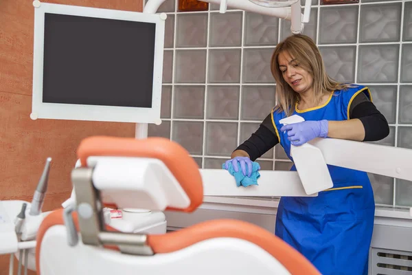 Mulher de limpeza em consultório odontológico — Fotografia de Stock