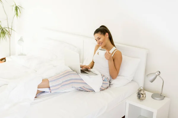 Nő laptoppal az ágyban — Stock Fotó
