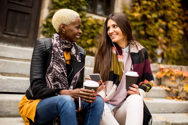 Multiracial unga kvinnor med telefonen utomhus — Stockfoto