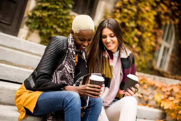 Multiracial young women with phone outdoor — Stock Photo, Image