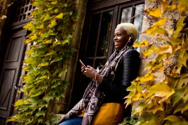 Telefon ile modern Afrikalı-Amerikalı kadın