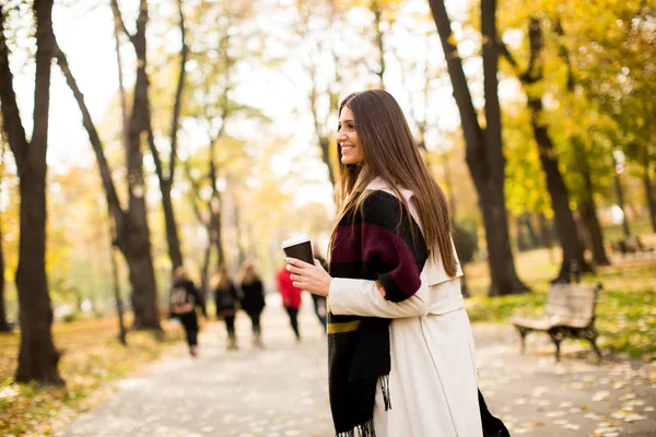 秋の公園でコーヒーを飲みながら若い女性 — ストック写真