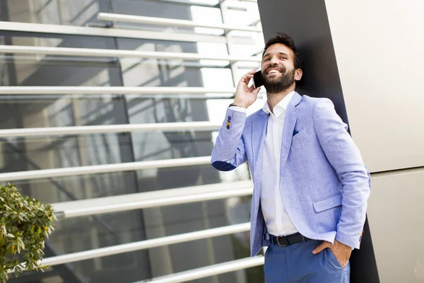 Homem de negócios moderno com telefone no escritório — Fotografia de Stock