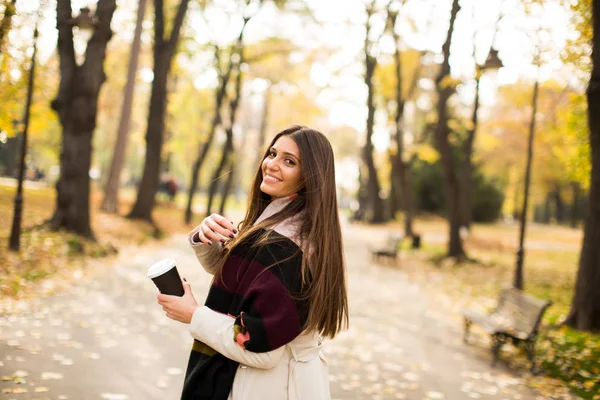 Kahve sonbahar parkta genç kadınla — Stok fotoğraf