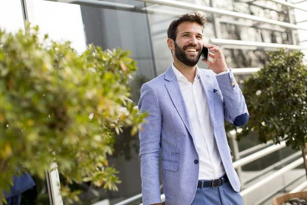 Современный бизнесмен с телефоном в офисе — стоковое фото