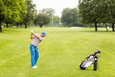 Golf oynayan genç adam.