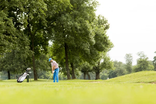 Ung man spelar golf — Stockfoto