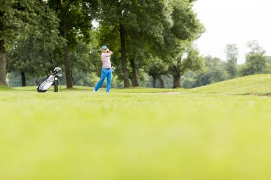 Golf oynayan genç adam.