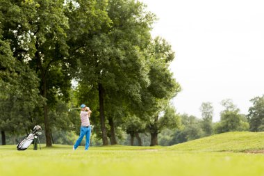 Golf oynayan genç adam.