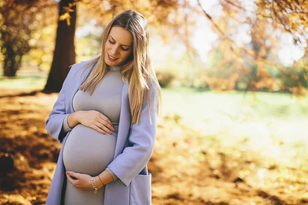 妊娠中の女性が公園でポーズ — ストック写真