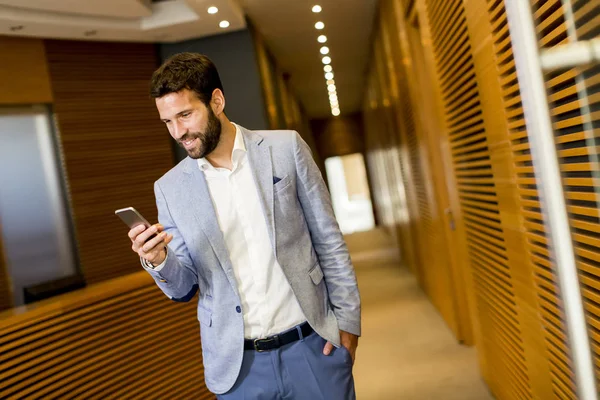 Homem de negócios moderno com telefone no escritório — Fotografia de Stock