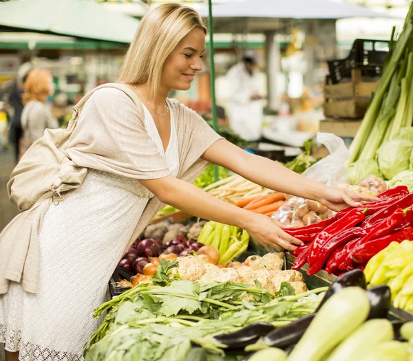 Kvinna köper grönsaker på marknaden — Stockfoto