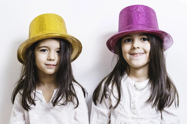 Zwei Mädchen posieren in glänzenden Hüten — Stockfoto