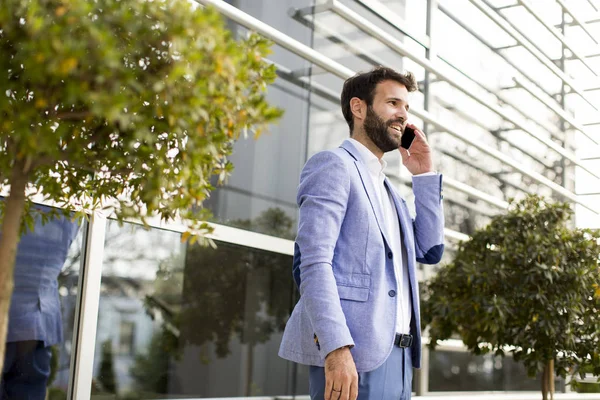 Современный бизнесмен с телефоном в офисе — стоковое фото