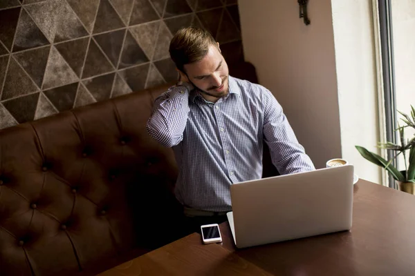 Young man with laptop and mobile phone — Stock Photo, Image