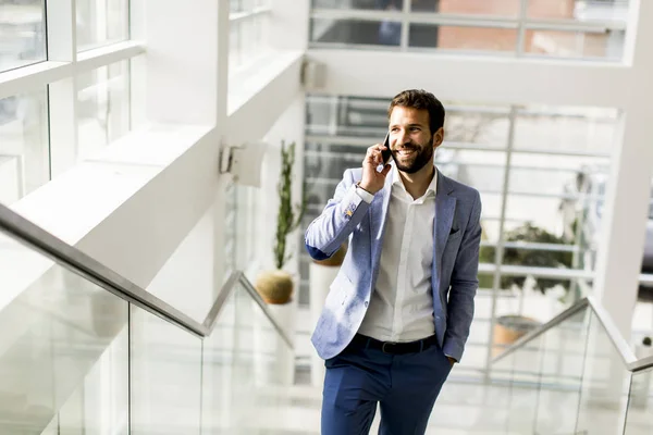 Homem de negócios moderno com telefone no escritório — Fotografia de Stock