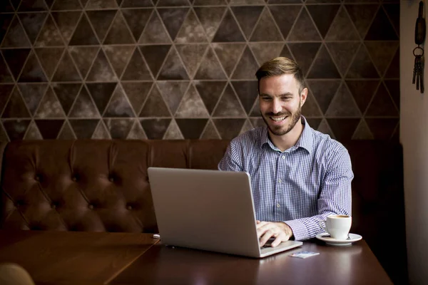 Young man with laptop and mobile phone — Stock Photo, Image