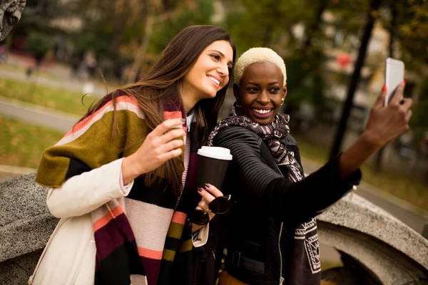 Multiracial young women with phone outdoor — Stock Photo, Image