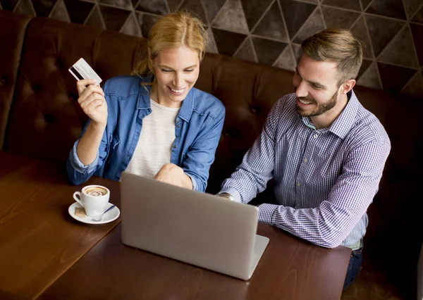 Unga par med laptop i restaurang — Stockfoto