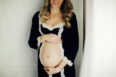 Yatak odasında hamile bir kadın var.