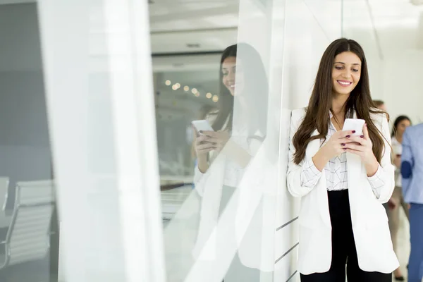 Businesswoman with phone in office — Stock Photo, Image