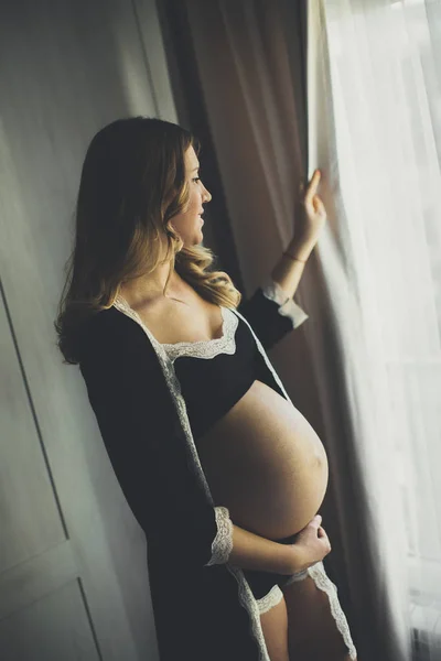 Mujer embarazada joven en el dormitorio — Foto de Stock