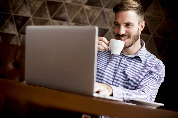 Young man with laptop in cafe — Stock Photo, Image